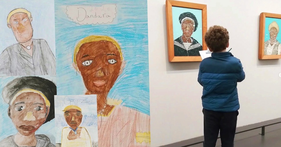 Crianças desenham e observam retratos de pessoas negras em galeria de arte.