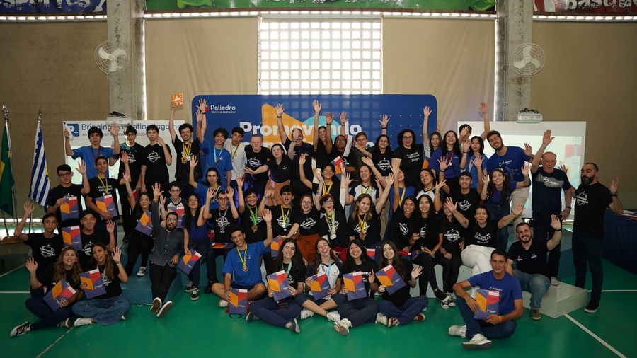 Grupo de estudantes e educadores comemora conquistas em evento das Olimpíadas Científicas.