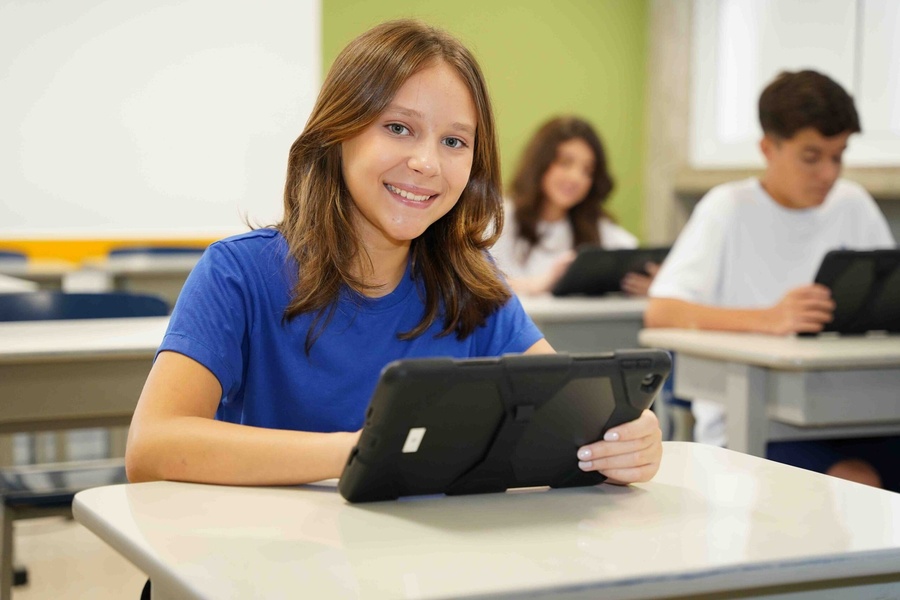 Aluna do Poliedro Colégio sorrindo com tablet